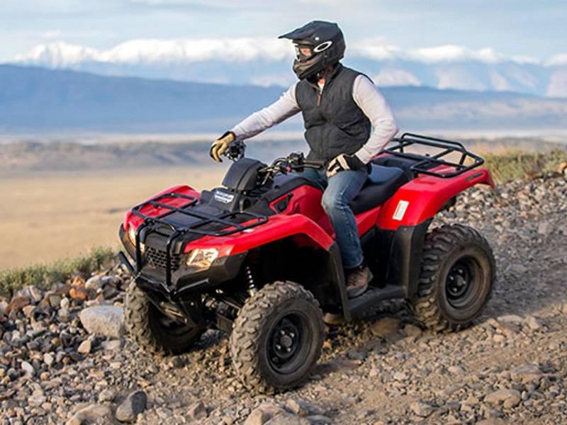 Homem em uma moto-quatro em um fundo de montanhas